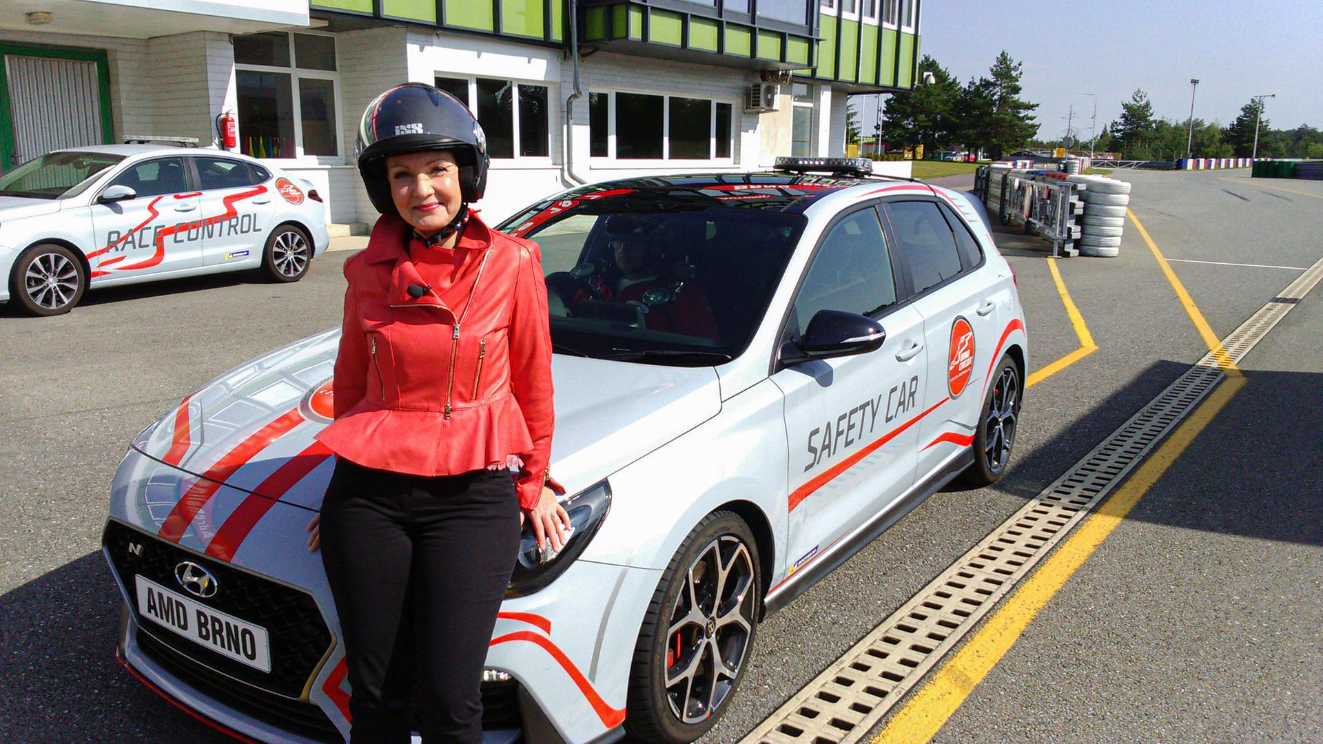 Eine Frau lehnt an einem Rennauto