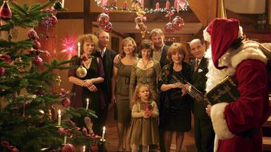 Die Familie steht vor dem festlich geschmückten Weihnachtsbaum zusammen, Sören (Matthias Schloo, rechts) ist als Weihnachtsmann verkleidet