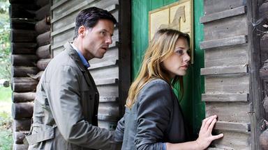 "Eine unbeliebte Frau": Oliver (Tim Bergmann) und Pia (Felicitas Woll) stehen vor einer verschlossenen Waldhütte und horchen hinein.