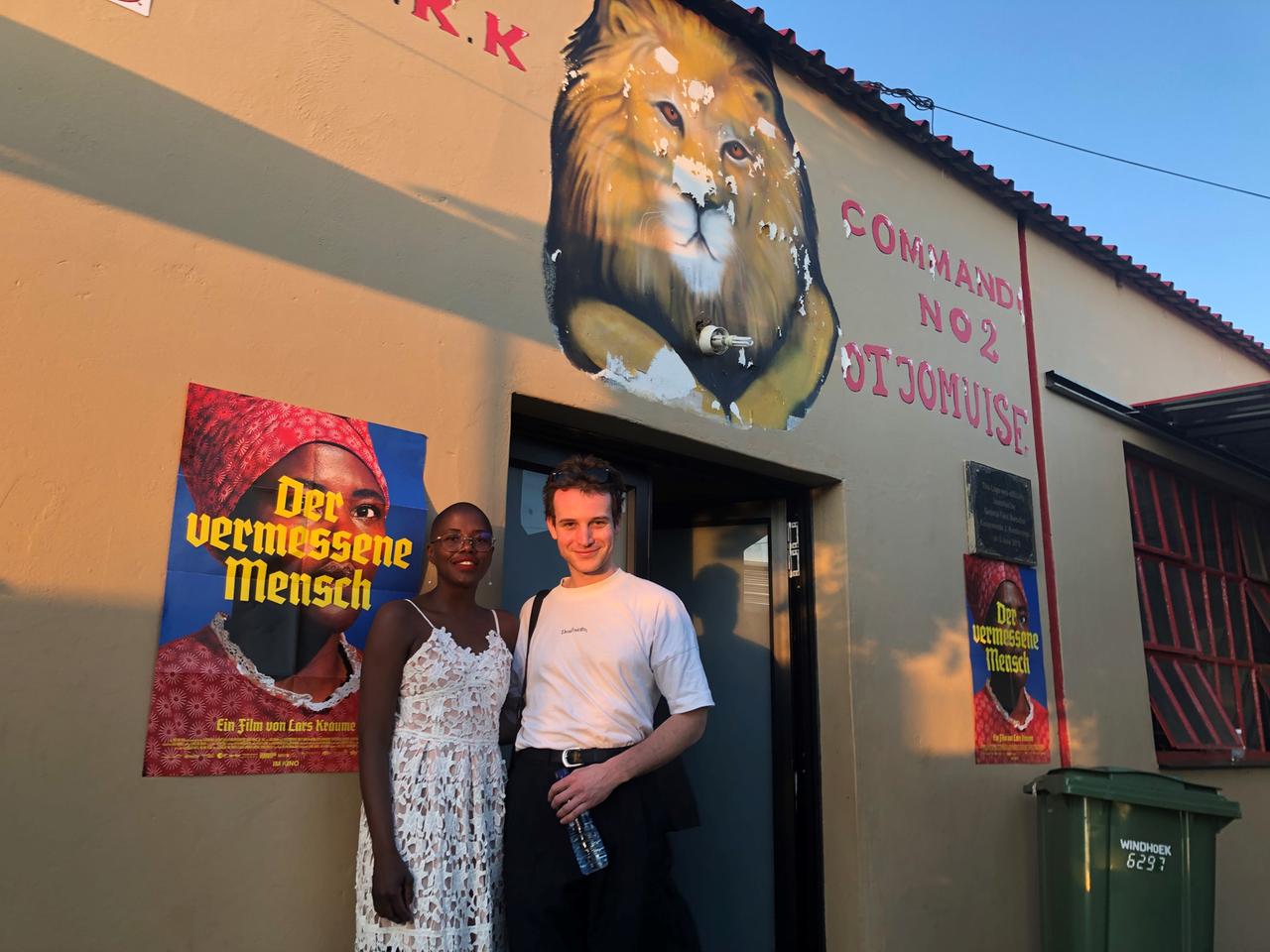 Hauptdarstellerin und Hauptdarsteller vor dem Filmplakat "Der vermessene Mensch".