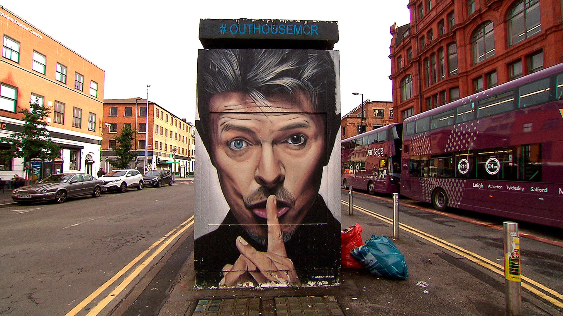 Straßenszene mit einem Graffito von David Bowie