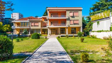 Bild eines zweistöckigen Gebäudes mit einstöckigem Nebenbau.