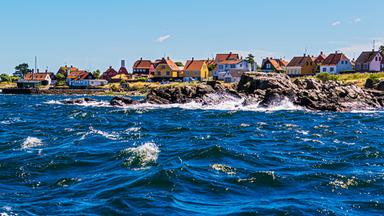 Eine flache Küste mit bunten Häusern.