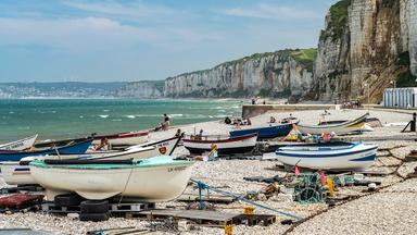 Fischerboote am Strand, im Hintergrund Felsklippen