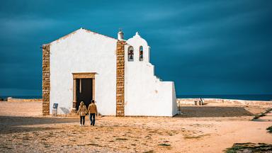 Ein Paar geht auf eine Kapelle zu