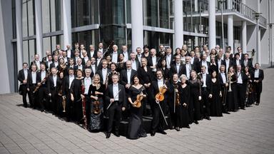 Musiker*innen vor einem Gebäude.