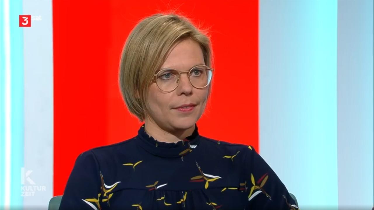 Porträtbild einer jungen Frau mit kurzen Haaren und Brille.