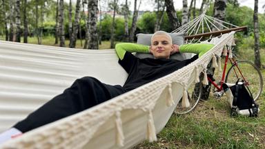 Junger Mann liegt in der Hängematte.