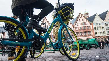 touristen fahren mit leihfahrraedern ueber den frankfurter roemerberg