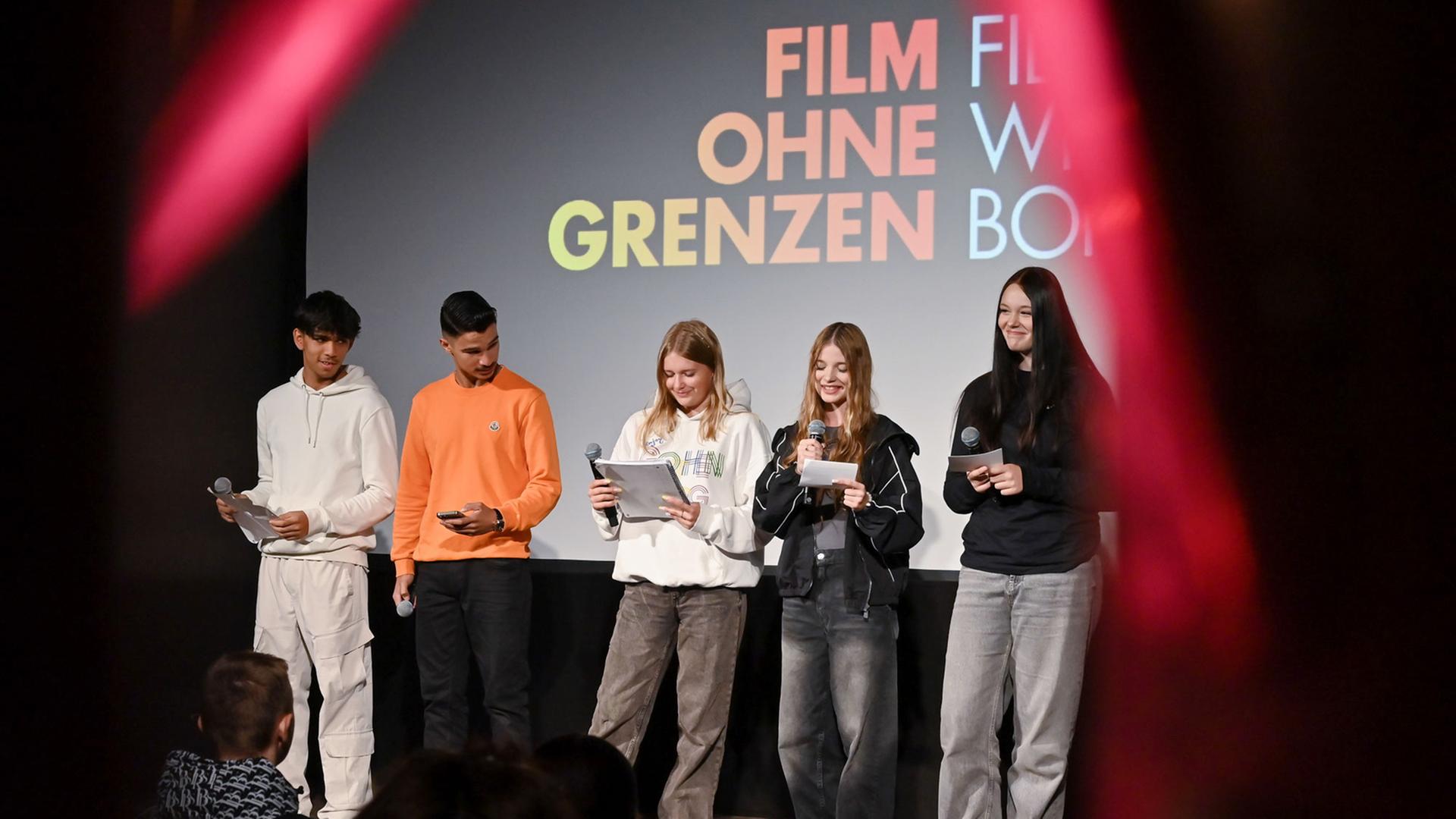 Junge Menschen stehen auf einer Festivalbühne.