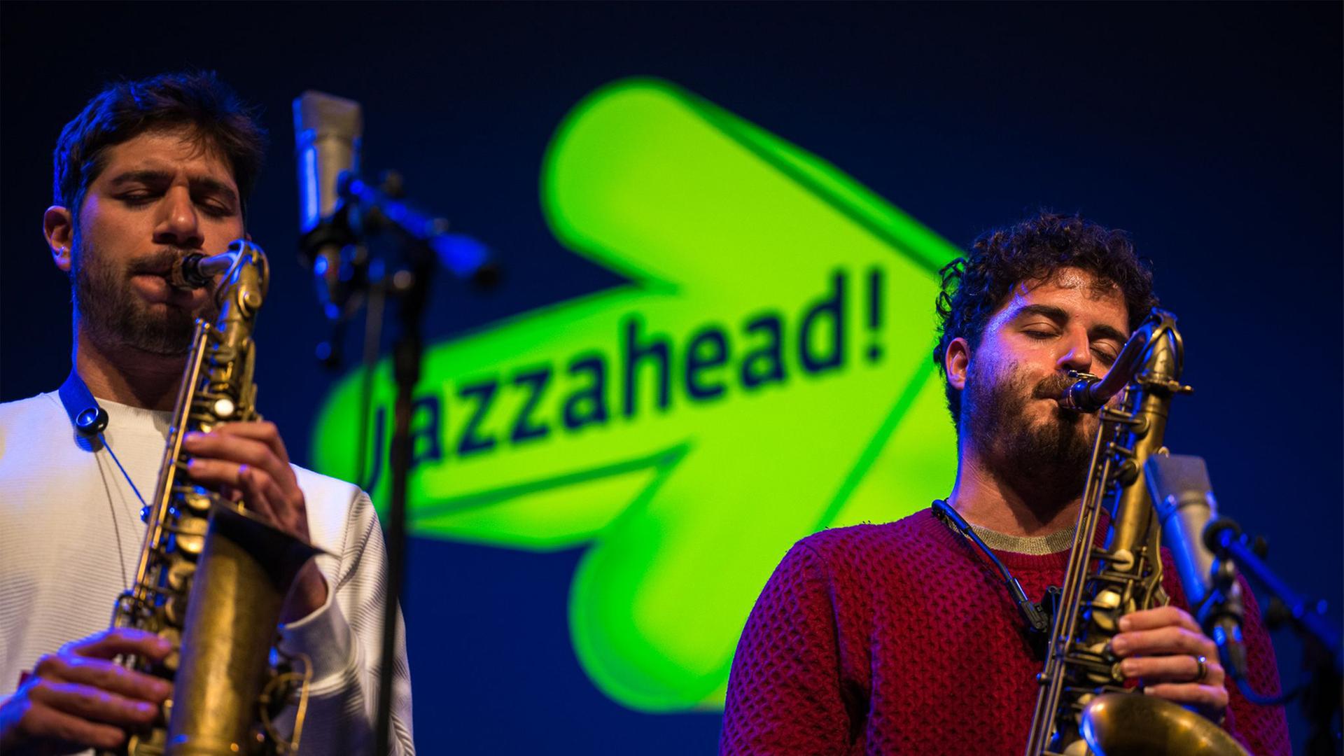 Man sieht zwei Jazzmusiker mit Saxophon auf der Bühne.