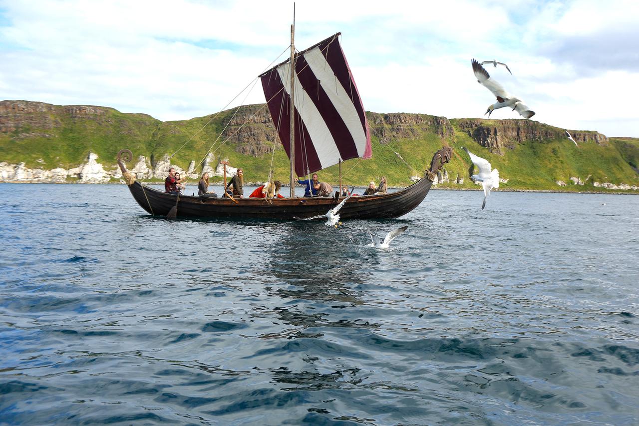 Reenactors Wikinger auf einem Schiff mit Seevögeln, Irland. 