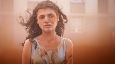 Man sieht eine Frau, die ein verschmutztes Oberteil trägt.