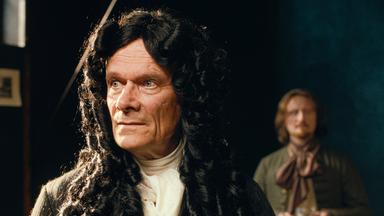 Ein Mann in historischem Gewand und Perücke schaut nach links.