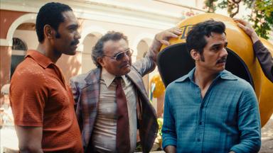 Vier Männer unterhalten sich auf einer Straße.