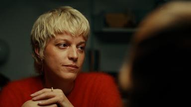 Frau mit kurzen hellen Haaren schaut auf 