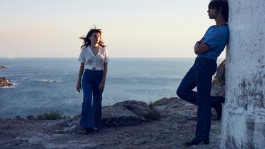 Frau und Mann stehen sich gegenüber am Meer