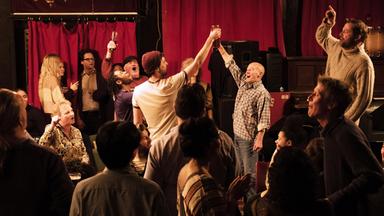 Mitglieder des Shantychors " Fisherman's Friends " singen und erheben ihre Gläser