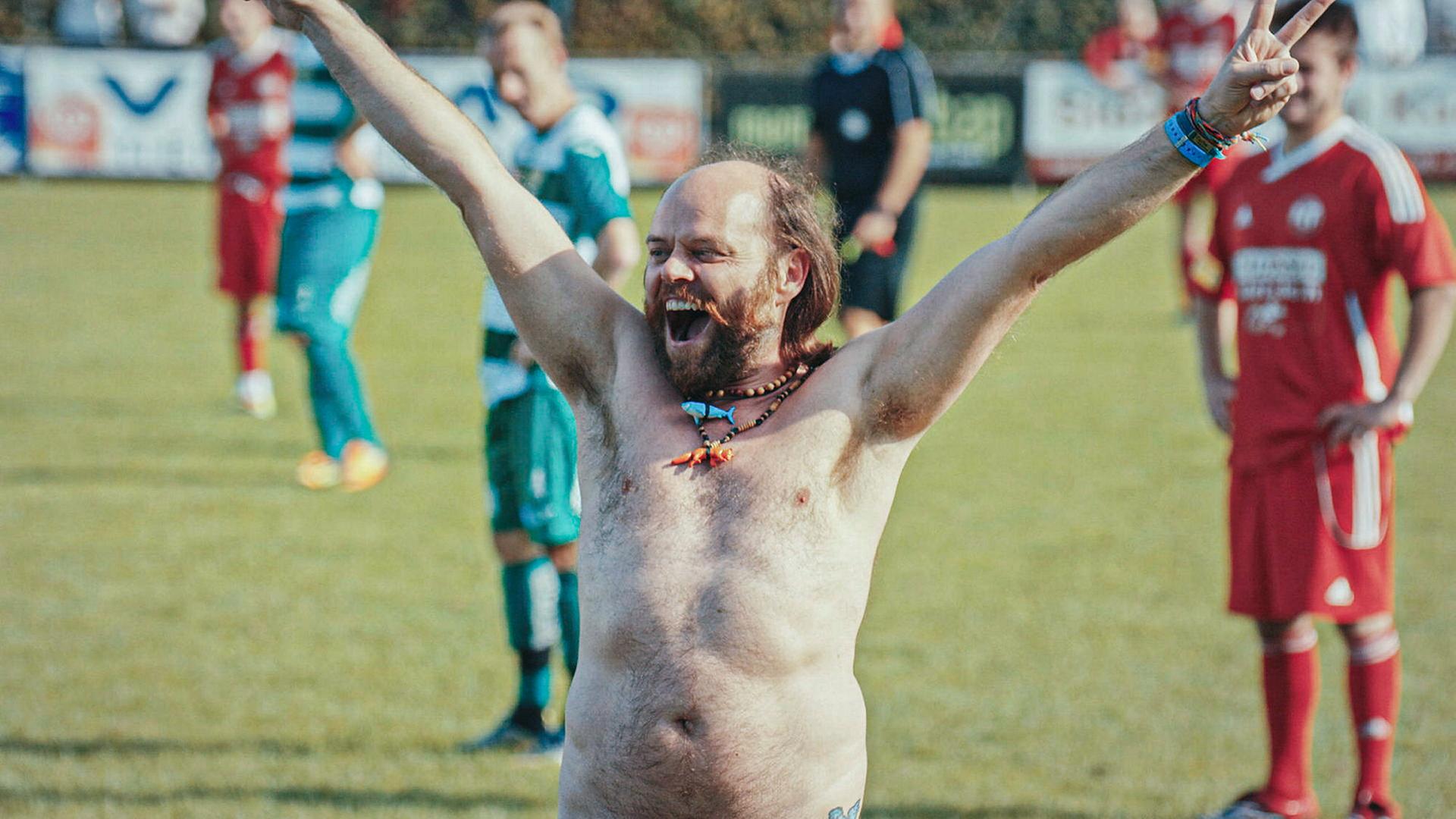 Jubelnder nackter Mann in Nahaufnahme auf Fußballfeld