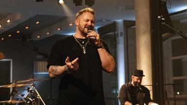 Florian Künstler singt in ein Mikrofon.