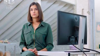 Eine Frau sitzt an einem Schreibtisch.