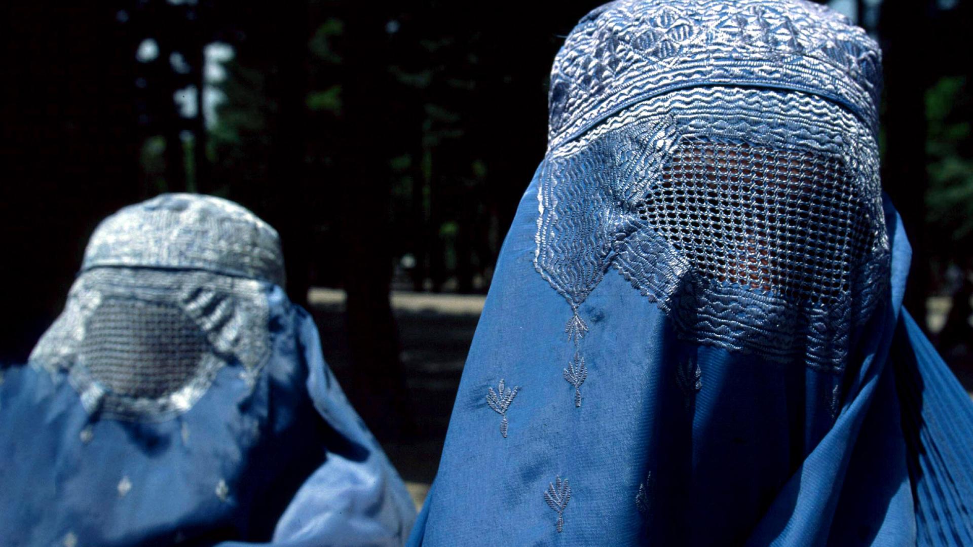 Zwei komplett mit blauen Schleiern verhüllte Frauen.