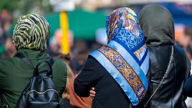 Rückansicht dreier Frauen mit Kopftuch.