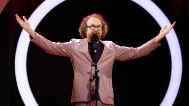 Friedemann Weise steht auf der Bühne und streckt seine Arme zur Seite aus.