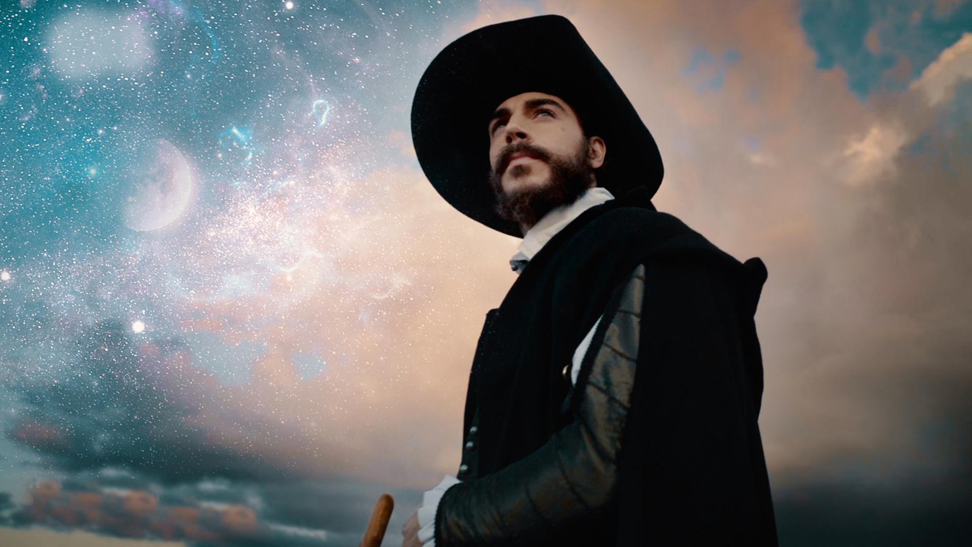 Spielszene. Galileo Galilei (Gaetano Tizzano)betrachtet zwei durchsichtige Fernrohrlinsen.