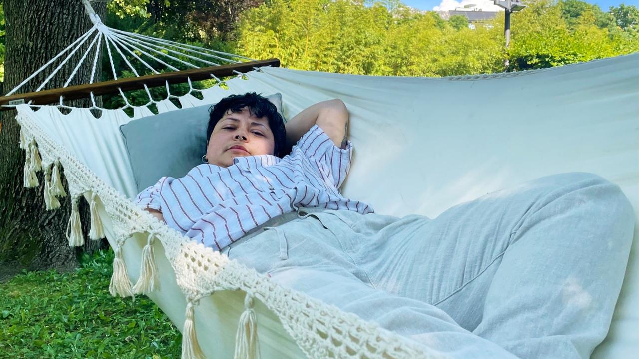 Rapper Gazal, transMann mit kurzen Haaren, liegt in einer Hängematte