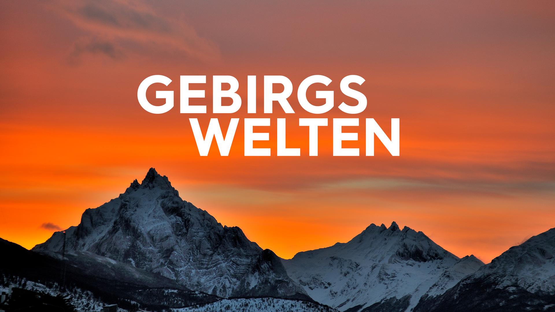 die Silhouette einer Gebirgskette vor orangenem Himmel