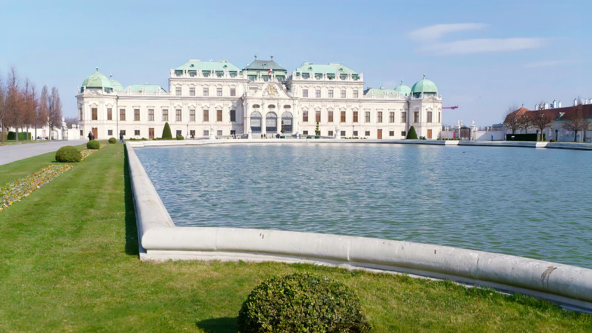Ansicht des Oberen Belvedere mit Teich und gepflegten Rasenflächen im Vordergrund.
