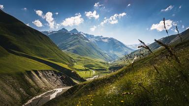 Blick auf eine grüne, hügelige Landschaft.