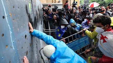 Demonstranten versuchen vor dem georgischen Parlament durch eine Metallbarriere durchzubrechen.