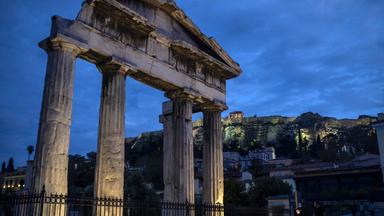 Angeleuchtete griechische Säulen bei Nacht.