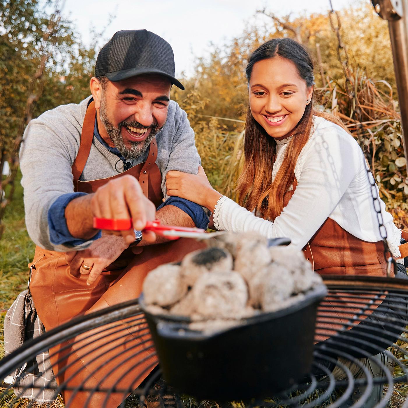Ein Mann und eine Frau vor einem Hängegrill.
