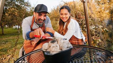 Ein Mann und eine Frau vor einem Hängegrill.