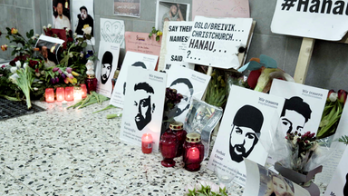 Rote Kerzen, Blumen, Bilder und Plakate liegen bzw. stehen auf dem Boden in Erinnerung an die Opfer des Anschlags in Hanau.