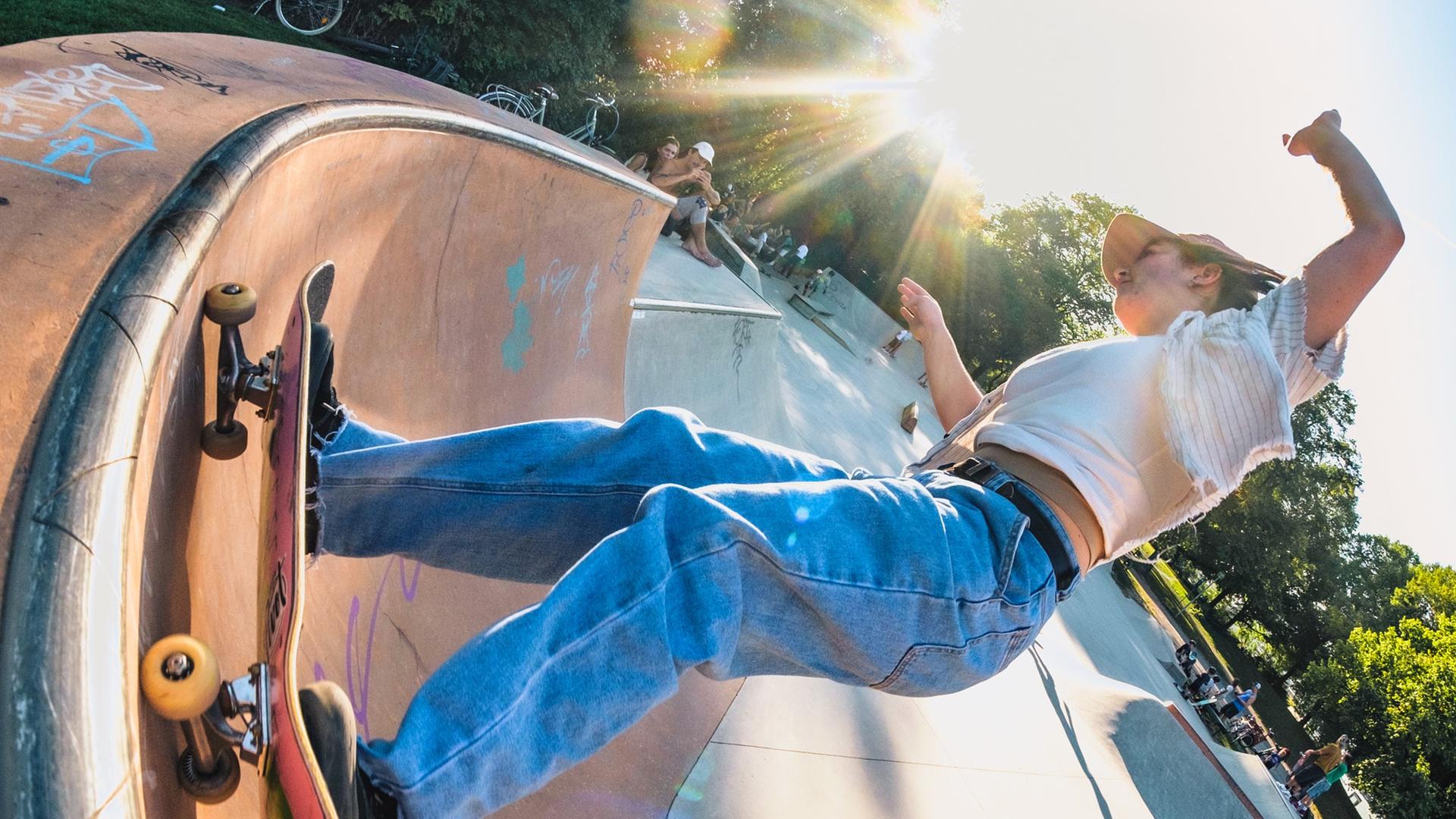 Vanessa Konte steht auf Skateboard, sie fährt seitlich in der Halfpipe.