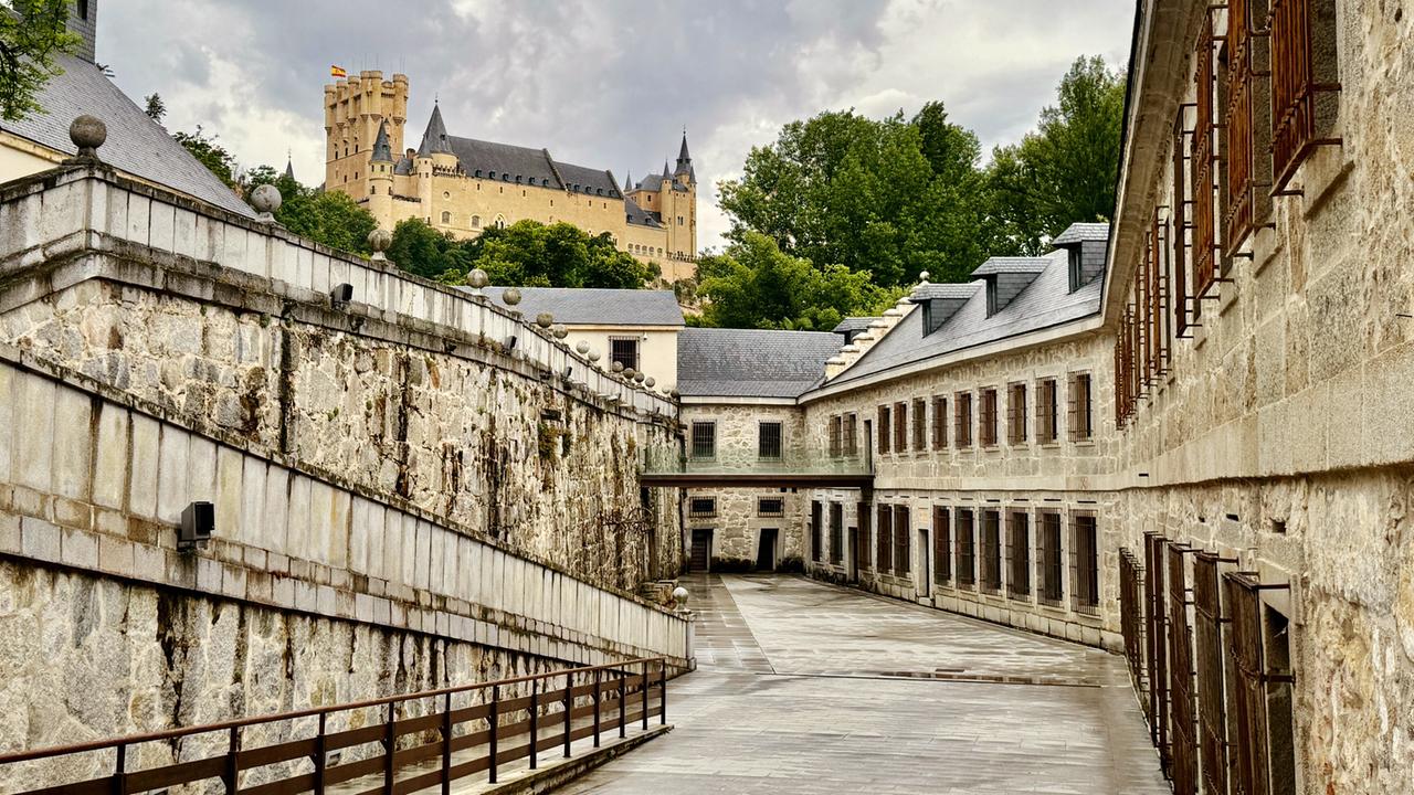 Ein großes altes Gebäude unter einer Burg liegend