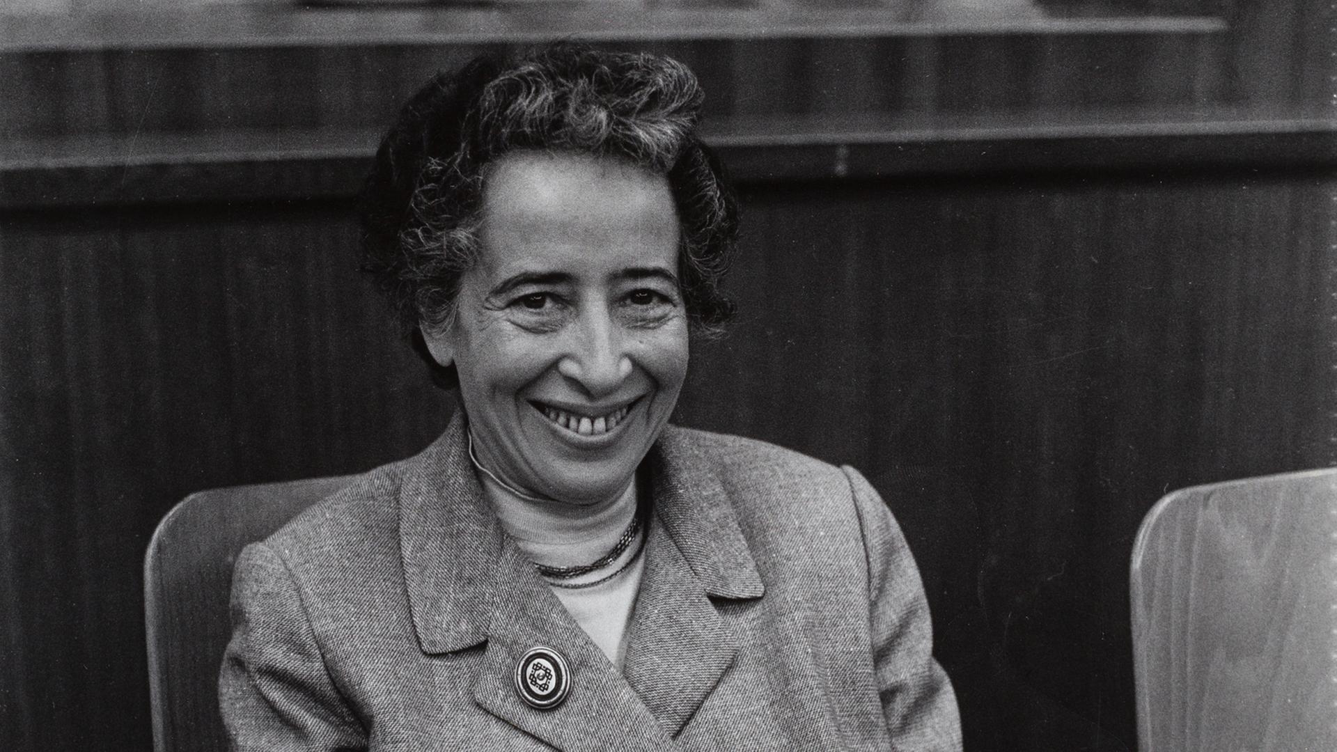 Altes Schwarz-Weiß-bild von einer Frau mittleren Alters, die in einem Stuhl sitzt und lächelt.