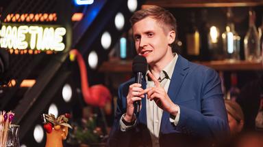 Das Bild zeigt Till Reiners bei der Moderation der Happy Hour.