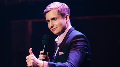 Das Bild zeigt Till Reiners bei der Moderation der Happy Hour.