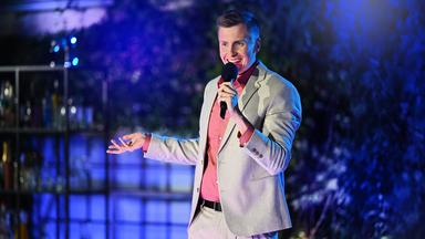 Mann auf abendlicher Open-Air Bühne.