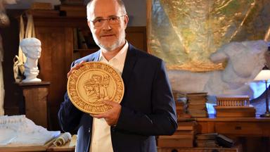 Prof. Harald Lesch hält den Maya-Kalender in die Kamera.