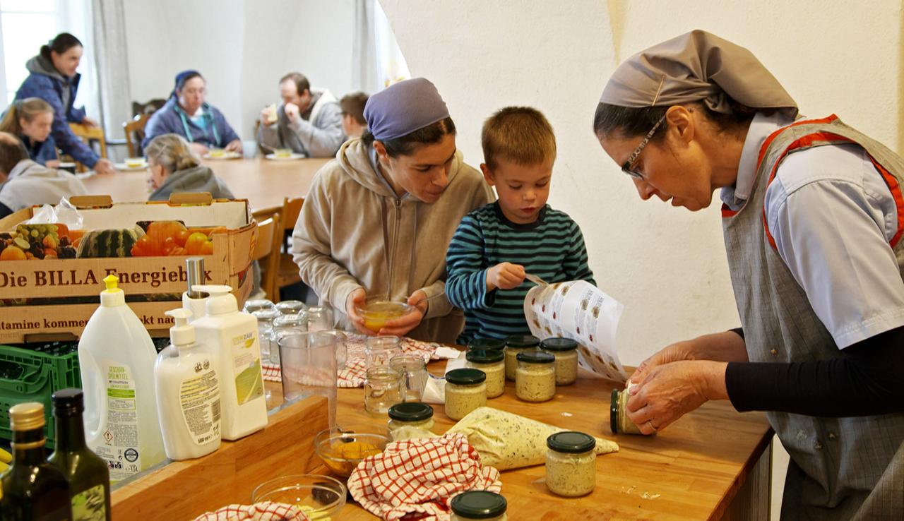 Mehrere Menschen beim Herstellen eines Produktes in Gläsern.