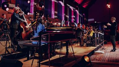 Ein Orchester auf einer Bühne.