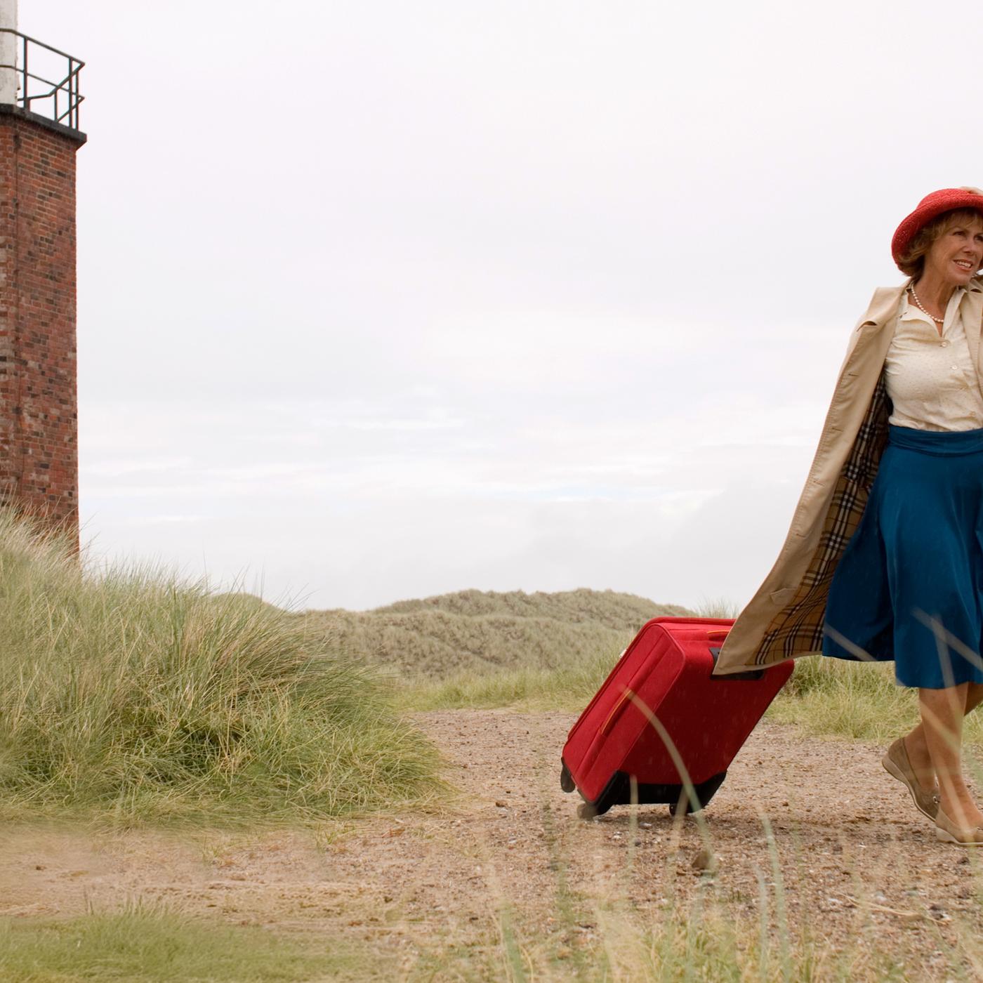 Auf der Insel Sylt läuft Inge (Gaby Dohm) an einem Leuchtturm vorbei. Sie zieht mit der rechten Hand einen Koffer hinter sich her und hält mit der anderen Hand ihren Hut auf dem Kopf fest.