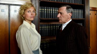 Margarete Oelkers (Nadja Uhl) verlangt von Amtsarzt Dr. Ahrens (Rudolf Kowalski) eine Bescheinigung, dass sie nie schizophren war. Sie wirft ihm vor, sie ohne Grund in die Klinik Wehnen eingewiesen zu haben. "Ich werde nicht schweigen": Margarete Oelkers (Nadja Uhl) und Amtsarzt Dr. Ahrens (Rudolf Kowalski) stehen vor einem Bücherregal. Margarete blickt in die Ferne, Ahrens blickt sie provozierend an.