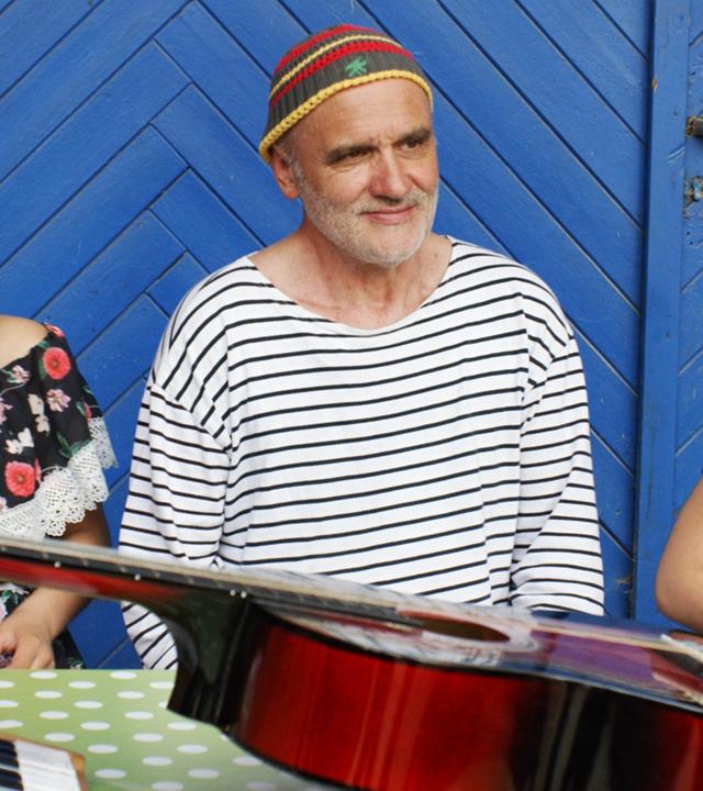 Ein Mann mit Bart sitzt zwischen zwei Mädchen.